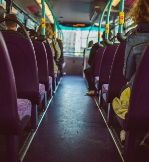 Nella fotto vediamo l'interno di un mezzo di trasporto pubblico - probabilmente un bus. La foto è simmetrica, con prospettiva centrale e sui toni del grigio.