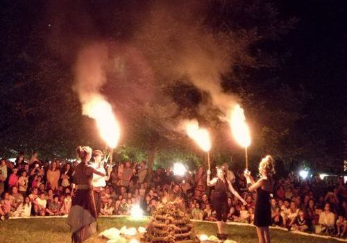 persone intorno a una pira per accendere il falò per la festa estate centro maiutica