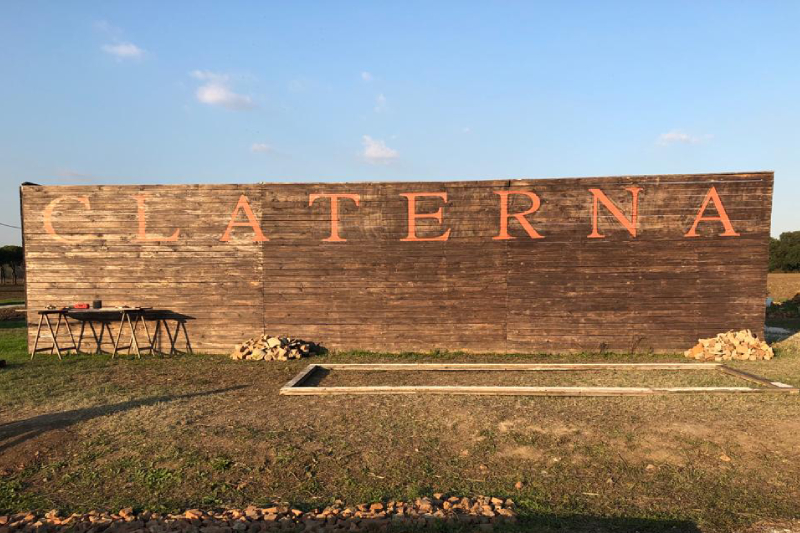 Area Archeologica della città di Claterna. In foto di vede un grande muro di mattoni con scritto "CLATERNA" al centro.