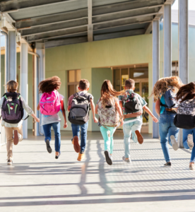 bambini che corrono di spalle in un corridoio scolastico luminoso